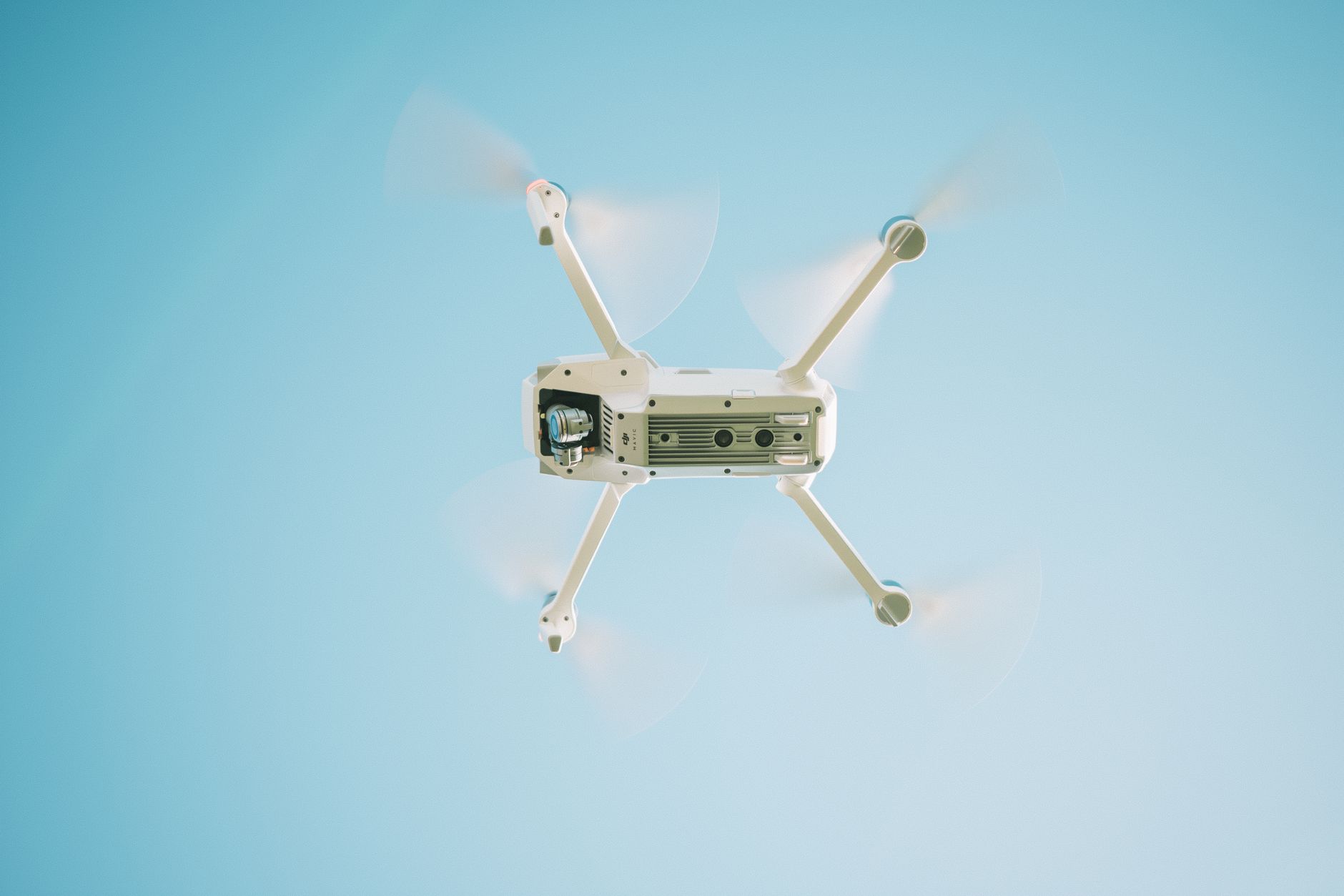 Delivery drone carrying a small package above suburban rooftops