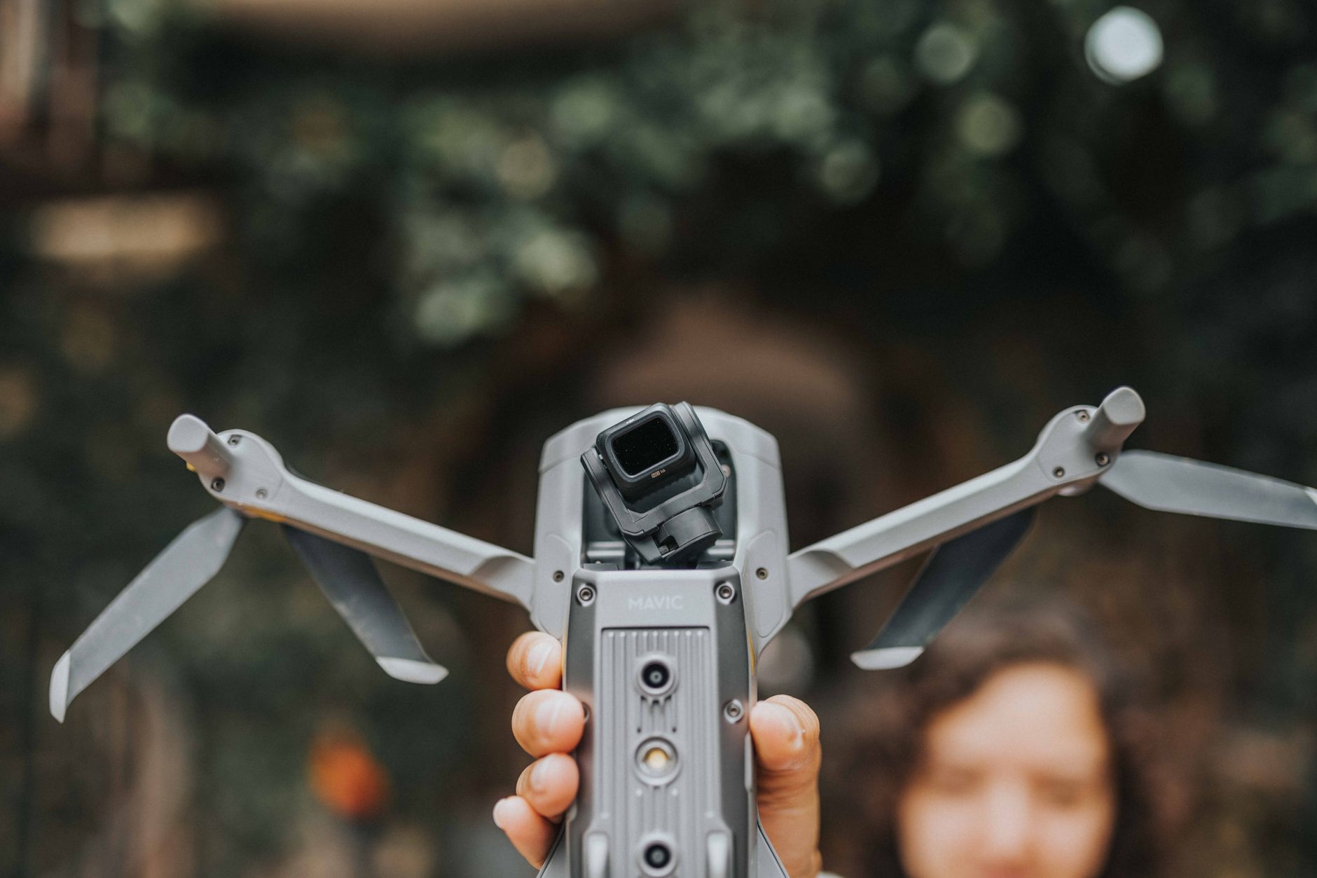 Pilot holding a compact camera drone before a flight
