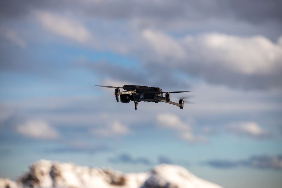 Aerial view of a drone flying over snow-covered mountains.
