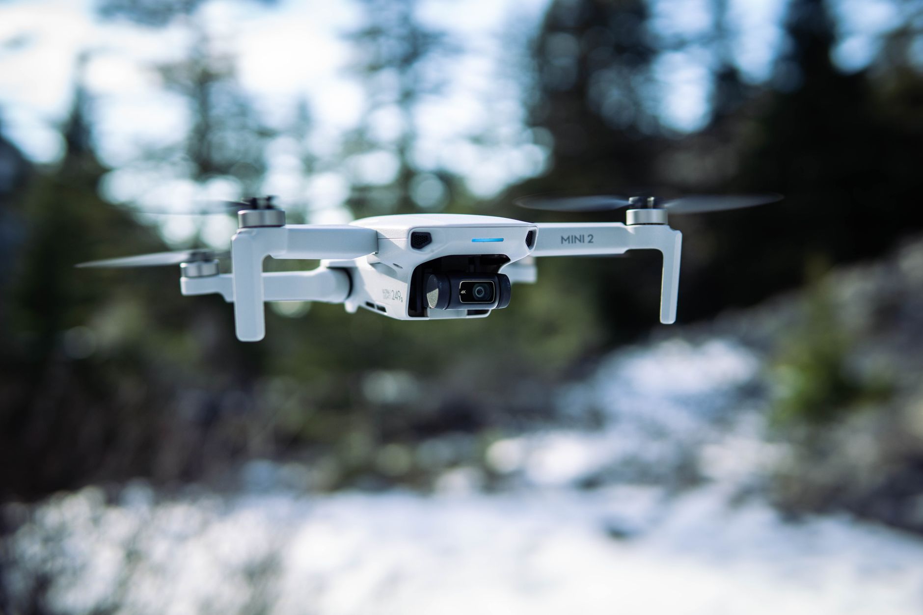 DJI Mini 4K drone hovering over a bright sky