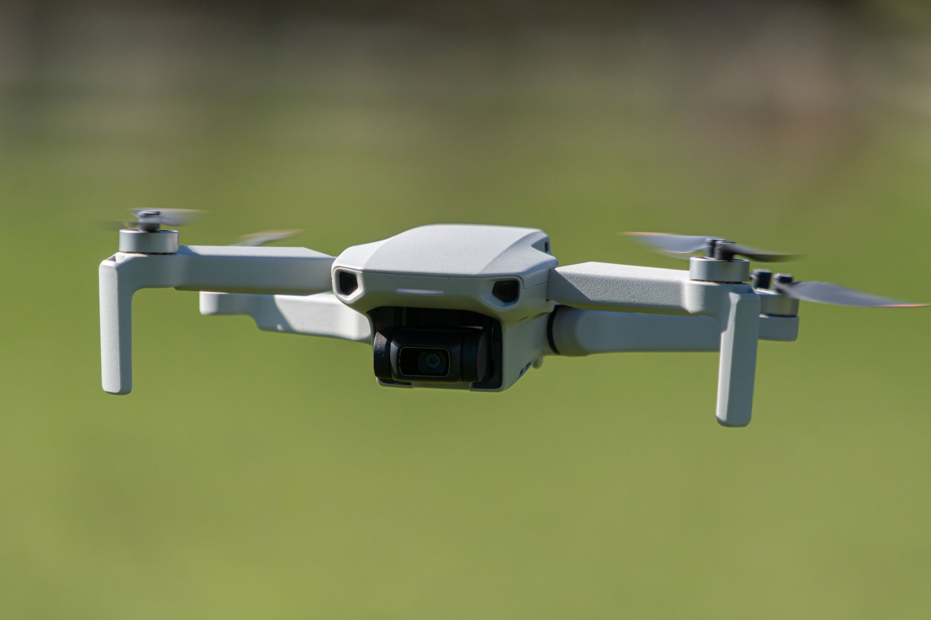 Potensic Atom SE budget drone flying over a green field