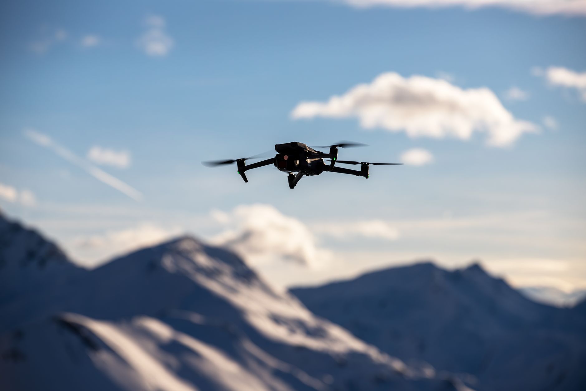 Camera drone hovering above a mountain valley at golden hour