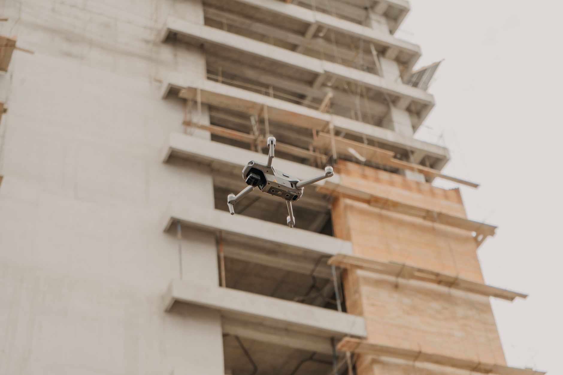 Surveyor preparing a large mapping drone on a construction site at sunrise