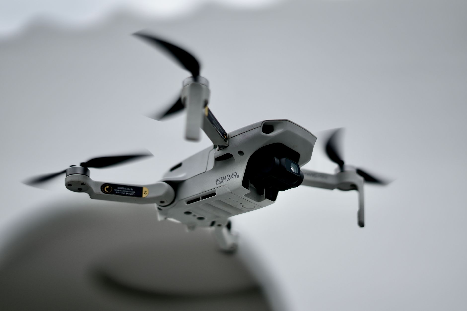 Commercial quadcopter drone hovering near a building roof during an inspection flight