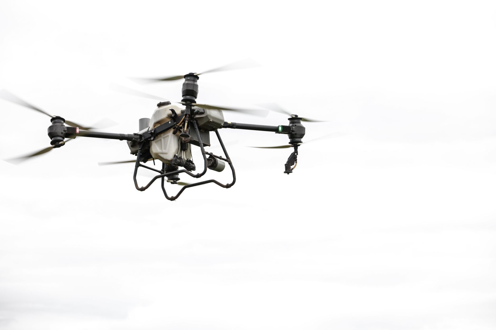 Large grey military surveillance drone in flight against a clear blue sky